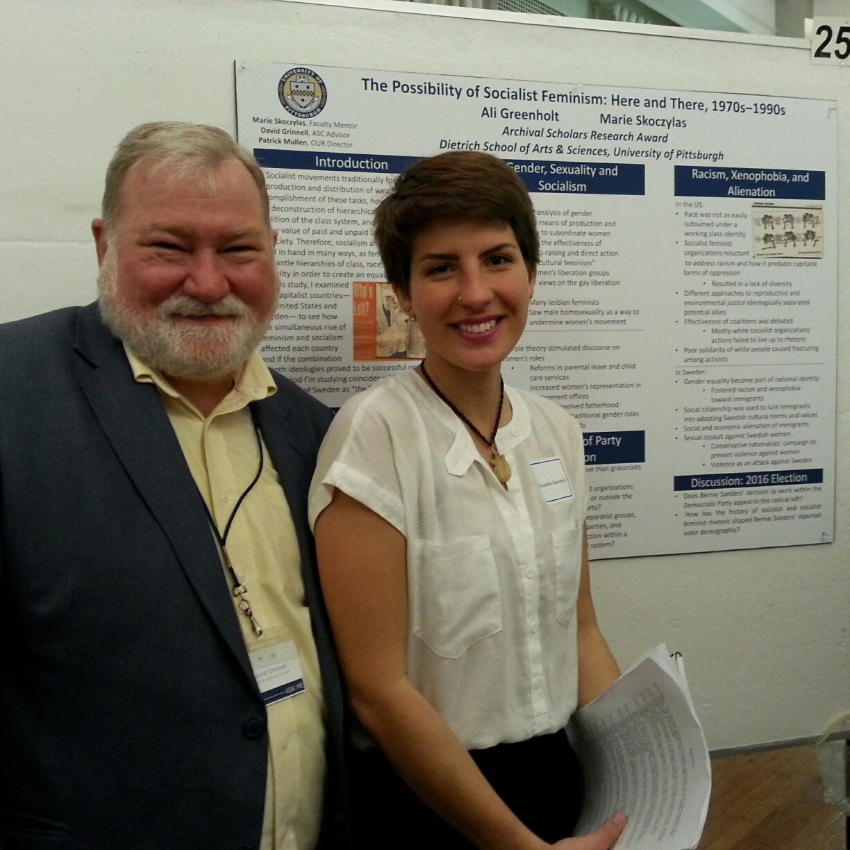 David Grinnell with Alexandria Greenhold standing in front of her poster