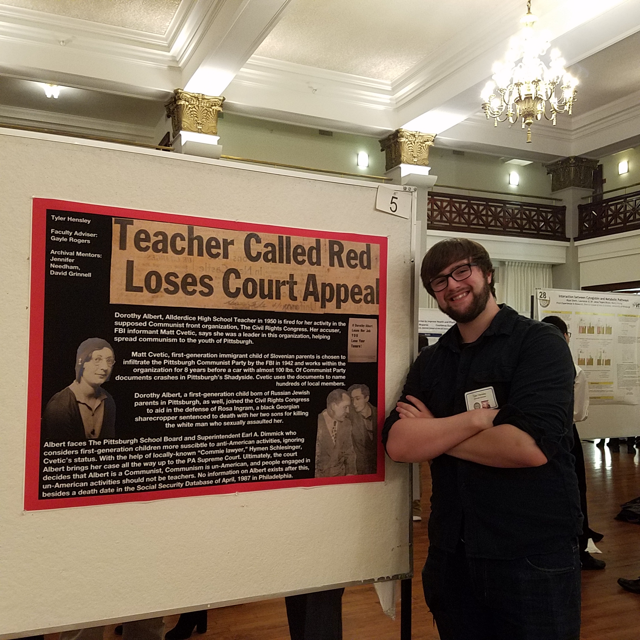 Tyler Hensley standing next to poster